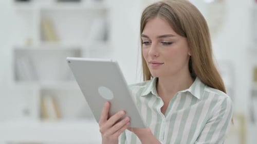 Woman Using Tablet Device at Home Indoors