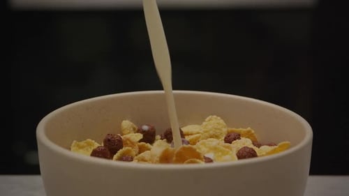 Pouring Milk on Cornflakes and Chocolate Puffs