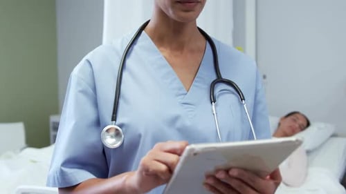 Frontansicht einer afroamerikanischen Ärztin mit digitalem Tablet auf der Station des Krankenhauses 4k