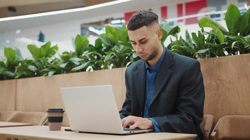 Entrepreneur Working Online on Laptop in Cafe