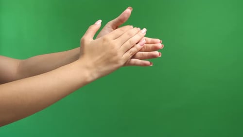 Femme tapant des mains sur fond d'écran vert