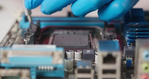 Gros plan des détails de réparation pour ordinateur portable Fixation de la micro-puce de la carte mère dans des gants de protection