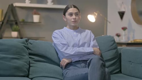 Hispanic Woman Sitting on Sofa Thinking