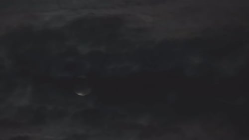 Full Moon Moving Behind Dark, Ominous Clouds