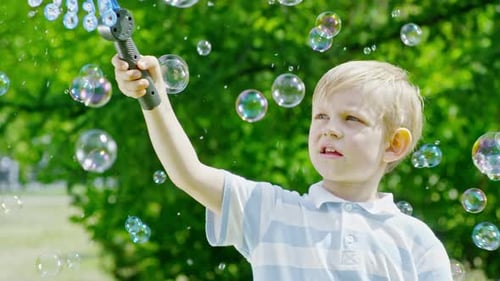 Boy Making Bubbles in a Green Park