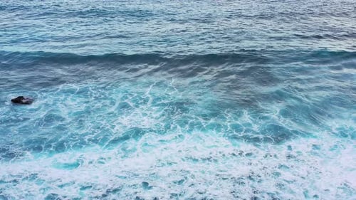 Waves and azure water as a background. View from high rock at the ocean surface.