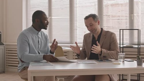 Businessmen Discussing Charts and Reaching Agreement in Office