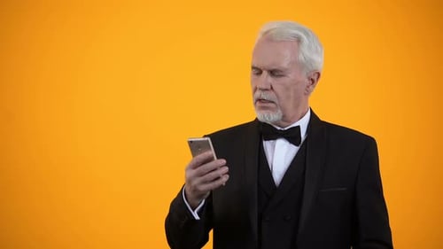 Senior Man Celebrates Financial Success with Smartphone and Cash