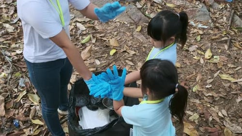 Children and Woman Clean Up Trash in Rural Nature