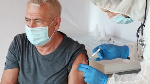 Senior Man Receiving Injection from Healthcare Worker