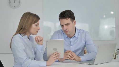 Colleagues Working Together on Tablet in Bright Office