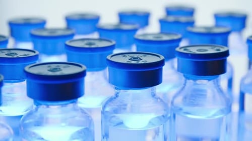Rows of Medicine Vials with Blue Caps