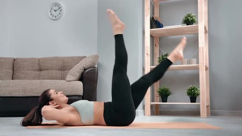 Woman Exercising at Home on Yoga Mat