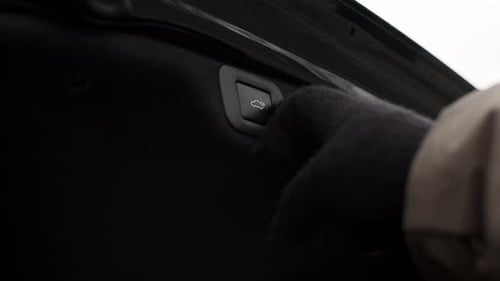 Hand in Black Glove Presses Button to Close Trunk of Luxury Sedan Business Car