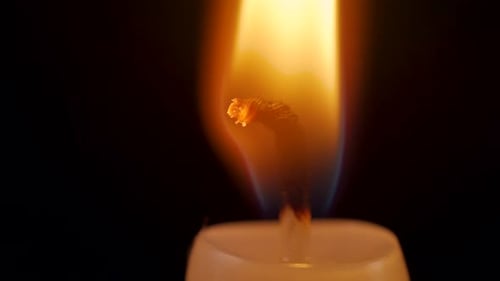 Closeup of an Isolated Burning Candle on a Black Background