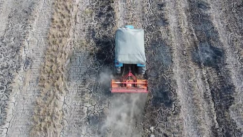 Tractor Plowing Field in Rural Farmland, Aerial View