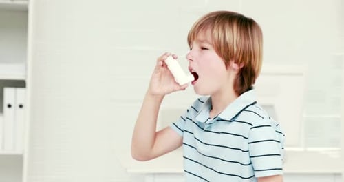 Boy Using Inhaler in Bright Examination Room