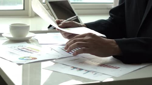 Executive Working at Desk Reviewing Charts