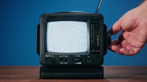 Hand Adjusting Retro Television with Static