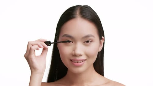 Woman Applying Mascara in a Close Up Shot
