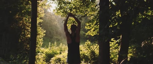 Man stretches while in forest