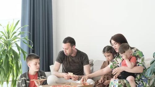 Family Enjoys Pizza Together on Couch