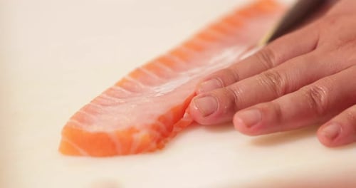 Cutting Salmon Meat With A Sharp Knife - Sushi Preparation - close up
