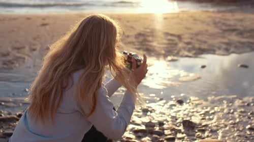 Fotógrafa feminina com foco na câmera slr na praia
