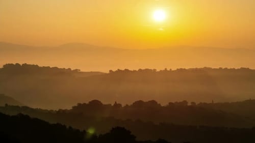 Golden Sunrise Over Misty Mountainous Landscape