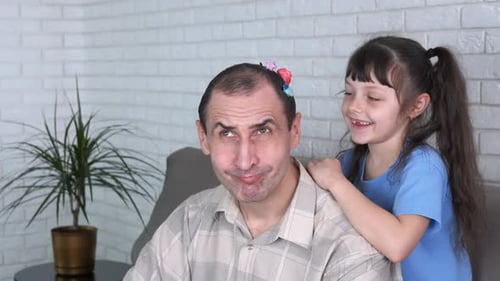 Child Plays with Father's Hair Indoors