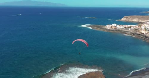 Paraglider Flying Over the Ocean. Aerial View
