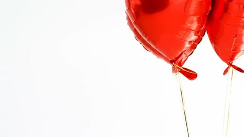 Festive Red Heart Balloons Floating on White Background