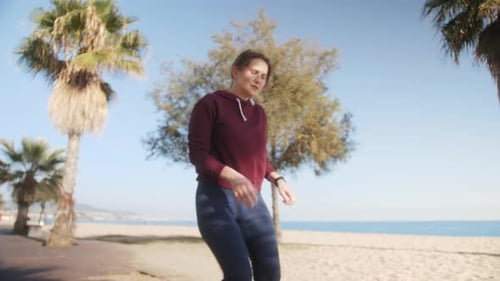 Woman Runner Resting Exhausted After Intense Cardio Workout Female Athlete Training on Beach in
