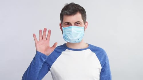Man Wearing Surgical Mask Stops Hand in Studio