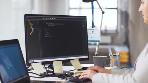 Woman Typing Code and Drinking Coffee at Desk