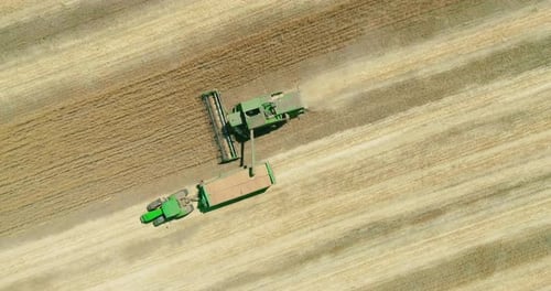 Aerial View of Combine and Tractor Harvesting Crops