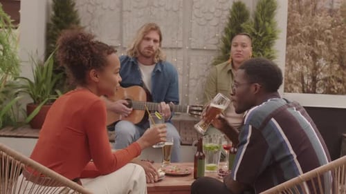 Friends Enjoying Drinks and Guitar on Rooftop