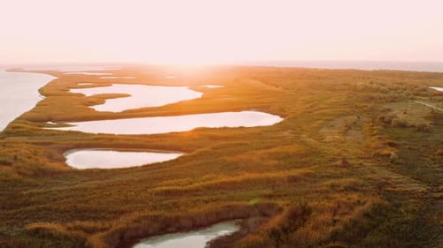 Aerial View of Lakes and Islets Near Black Sea on Backdrop of Summer Sunset. Stunning Flight Over