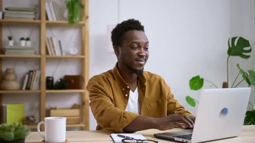 Man Working on Laptop at Home Office Desk