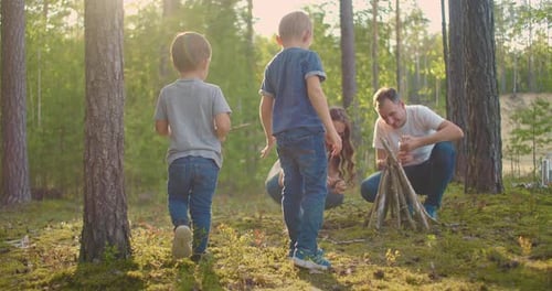 Family Sits Around a Campfire on a Summer Evening. Children with Their Parents Are Resting in the