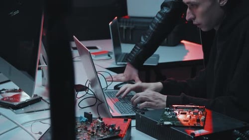 Intense Young Adults Hacking Computers at Night