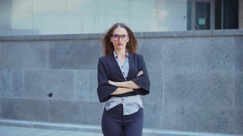 Confident Woman Stands Outside Gray Building