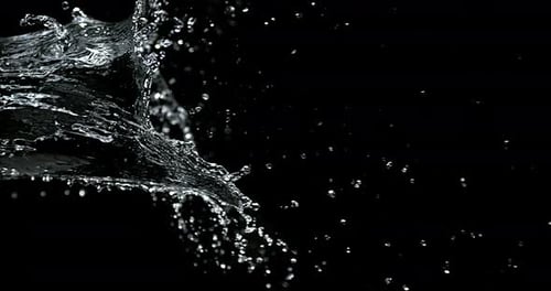 L'eau jaillit sur fond noir, ralenti 4K