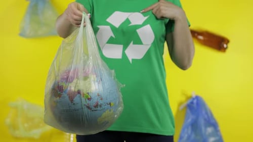 Mujer irreconocible con globo terráqueo en paquete de plástico. Salva la ecología. Contaminación natural plástica