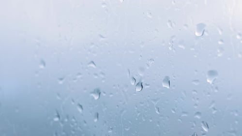 Rain Drops Streaking Down a Window