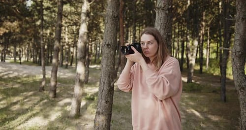 Young Woman Photographer Takes Pictures of the Forest Using Digital Camera