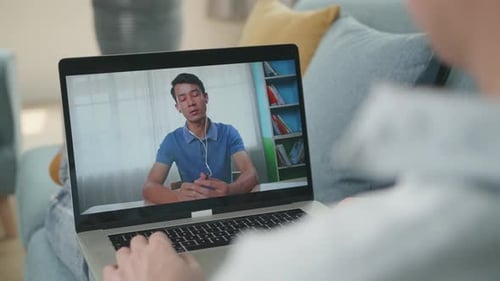 Person on Video Call Using Laptop on Couch