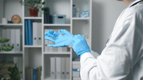 Un médecin ou une infirmière met des gants chirurgicaux en nitrile bleu, sécurité médicale professionnelle, chirurgie hygiénique