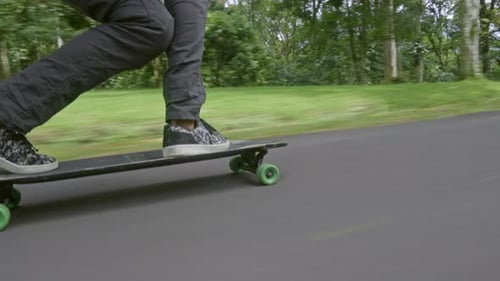 Skateboarder Longboarding Down Lush Rural Road