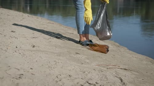 Picking Up Plastic Trash on Sandy River Bank